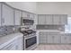 Well-equipped kitchen featuring stainless appliances, quartz countertops, backsplash, and plenty of cabinet space at 4010 Hemphill St, North Las Vegas, NV 89032
