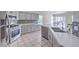 Modern kitchen with stainless steel appliances, countertops, breakfast bar, tile floors, and adjacent dining area at 4010 Hemphill St, North Las Vegas, NV 89032
