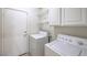 Laundry room with a side-by-side washer and dryer, overhead shelving, and access to the exterior at 4010 Hemphill St, North Las Vegas, NV 89032