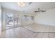 Spacious living room with tile flooring, ceiling fan, and sliding glass door to the backyard patio at 4010 Hemphill St, North Las Vegas, NV 89032