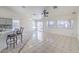 Large living area with tile flooring, a breakfast bar, multiple windows, and ceiling fans at 4010 Hemphill St, North Las Vegas, NV 89032