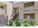 Multi-story condominium exterior with patios, stairs, garden landscaping, and a tan stucco facade at 5038 S Rainbow Blvd # 206, Las Vegas, NV 89118