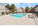 Community pool with sun loungers, black fencing, and adjacent residential buildings at 5038 S Rainbow Blvd # 206, Las Vegas, NV 89118