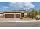 Charming home featuring a three-car garage, stone accents, and desert landscaping, offering curb appeal at 5234 Savannah Rose St, Las Vegas, NV 89149
