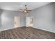 Large bedroom with wood-look floors, neutral walls, and two open doorways at 525 Sun Mountain Ave, North Las Vegas, NV 89031