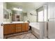 Bright bathroom with double sinks, bathtub, and a separate glass shower at 5620 Siena Rose St, North Las Vegas, NV 89031