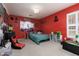 A bedroom with red walls and a full bed with posters hung on the wall at 5620 Siena Rose St, North Las Vegas, NV 89031
