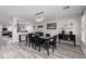 Bright dining room with a modern chandelier, gray-wash wood floors and access to living and kitchen at 5620 Siena Rose St, North Las Vegas, NV 89031