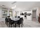 Bright dining room with a modern chandelier, gray-wash wood floors, and black dining set at 5620 Siena Rose St, North Las Vegas, NV 89031