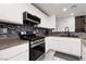 Modern kitchen with stainless steel oven, range and a mosaic tile backsplash at 5620 Siena Rose St, North Las Vegas, NV 89031