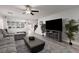 Modern living room with plush seating, stylish decor, hardwood floors and a large TV at 5620 Siena Rose St, North Las Vegas, NV 89031