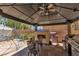 Outdoor patio with covered seating area, grill, and play structure for a relaxing space at 5620 Siena Rose St, North Las Vegas, NV 89031