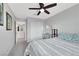 Bright bedroom with a ceiling fan, closet, carpet flooring, and a desk with a mirror at 6619 Frosted Harvest Ave, Las Vegas, NV 89108