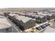 Community aerial view with gray and brown townhomes and garages featuring mountain views and street parking at 668 Tiarella Ln, Henderson, NV 89015