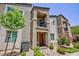 Well-maintained townhome with cozy front porch and lovely landscaping, including colorful flowering shrubs at 668 Tiarella Ln, Henderson, NV 89015