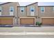 Attached two-car garages for convenient parking and storage, complete with exterior lighting at 668 Tiarella Ln, Henderson, NV 89015