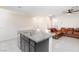 Stylish kitchen island featuring granite countertops and seating, adjacent to a cozy living area at 668 Tiarella Ln, Henderson, NV 89015