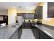 Well-lit kitchen featuring stainless steel appliances, granite countertops, and dark cabinetry at 668 Tiarella Ln, Henderson, NV 89015