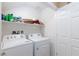 Functional laundry room with modern washer and dryer set, storage shelf, and ample space at 668 Tiarella Ln, Henderson, NV 89015