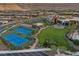 Aerial view showing tennis courts, clubhouse, and surrounding residential area with mountain views at 6804 Regency Stone Way, Las Vegas, NV 89148