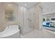Modern bathroom with a freestanding tub, glass-enclosed shower, and neutral tile at 6804 Regency Stone Way, Las Vegas, NV 89148