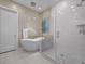 Modern bathroom featuring a soaking tub and a glass-enclosed shower with unique white tile at 6804 Regency Stone Way, Las Vegas, NV 89148