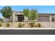 This single-story home features a stone exterior, desert landscaping, and a two-car garage at 6804 Regency Stone Way, Las Vegas, NV 89148