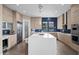 Modern kitchen featuring stainless steel appliances, ample cabinetry, a waterfall island, and a stylish backsplash at 6804 Regency Stone Way, Las Vegas, NV 89148