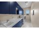 The modern laundry room has blue cabinets, white countertops, a sink, and washer and dryer at 6804 Regency Stone Way, Las Vegas, NV 89148