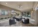 An inviting covered patio features a ceiling fan, modern furniture, and views of the yard and interior at 6804 Regency Stone Way, Las Vegas, NV 89148