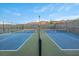 Close up shot of two tennis courts, with net and fencing, ready for a match at 6804 Regency Stone Way, Las Vegas, NV 89148