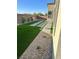 Backyard with artificial turf, stone pavers, rock landscaping, and brick perimeter wall at 6834 Compass St, North Las Vegas, NV 89084