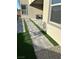 Backyard features a walkway with artificial turf and seating area at 6834 Compass St, North Las Vegas, NV 89084