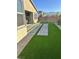 A well-manicured backyard with artificial grass, pavers, rocks, and a brick perimeter wall for privacy at 6834 Compass St, North Las Vegas, NV 89084