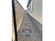 Narrow side yard has stone pavers and gravel leading along the side of the house at 6834 Compass St, North Las Vegas, NV 89084