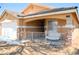 Charming home exterior with a covered front porch and swing, complemented by desert landscaping at 7340 Alpine Ridge St, Las Vegas, NV 89131