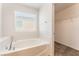 Close-up of a soaking tub under a window, next to a closet, creating a relaxing and functional space at 7553 Virginia Dale St, Las Vegas, NV 89131