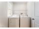 Functional laundry area with modern washer and dryer setup and a bright window at 7553 Virginia Dale St, Las Vegas, NV 89131