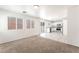 Spacious living room featuring carpet, tile flooring, and a kitchen with stainless steel appliances at 7553 Virginia Dale St, Las Vegas, NV 89131