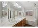 Bright bathroom featuring dual sinks, a soaking tub and a glass enclosed shower at 7927 Villa Salsa Ave, Las Vegas, NV 89131