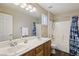 Bathroom features a double sink vanity, bath tub and shower with a curtain at 7927 Villa Salsa Ave, Las Vegas, NV 89131