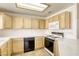 Clean kitchen with wooden cabinets, white appliances, and black dishwasher/stove at 8301 Boseck Dr # 232, Las Vegas, NV 89145