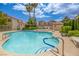 Community pool with crystal blue water, palm trees, and surrounding condominiums under a blue sky with fluffy clouds at 8301 Boseck Dr # 232, Las Vegas, NV 89145