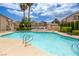 Community pool with crystal blue water, palm trees, and surrounding condominiums under a blue sky with fluffy clouds at 8301 Boseck Dr # 232, Las Vegas, NV 89145