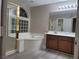 Bathroom with a separate shower, tub, and vanity with dark wood cabinets at 9556 Ancala Hollow Ct, Las Vegas, NV 89148