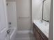 Well-lit bathroom featuring dual sinks, a shower-tub combo, and modern fixtures at 9556 Ancala Hollow Ct, Las Vegas, NV 89148