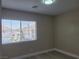 Neutral bedroom with a bright window and view of the houses in the neighborhood at 9556 Ancala Hollow Ct, Las Vegas, NV 89148