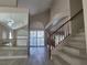 Home foyer with wood staircase, stylish floors, natural light, and modern wall mirror at 9556 Ancala Hollow Ct, Las Vegas, NV 89148