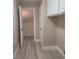 Hallway with white cabinets, a closet, and wood-look tile flooring at 9556 Ancala Hollow Ct, Las Vegas, NV 89148