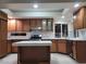 Well-lit kitchen with stylish lighting, white countertops, wooden cabinets, and stainless-steel appliances at 9556 Ancala Hollow Ct, Las Vegas, NV 89148